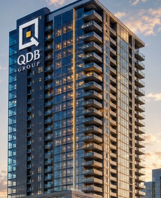 A glass residential tower with balconies on every floor, lit at sunset